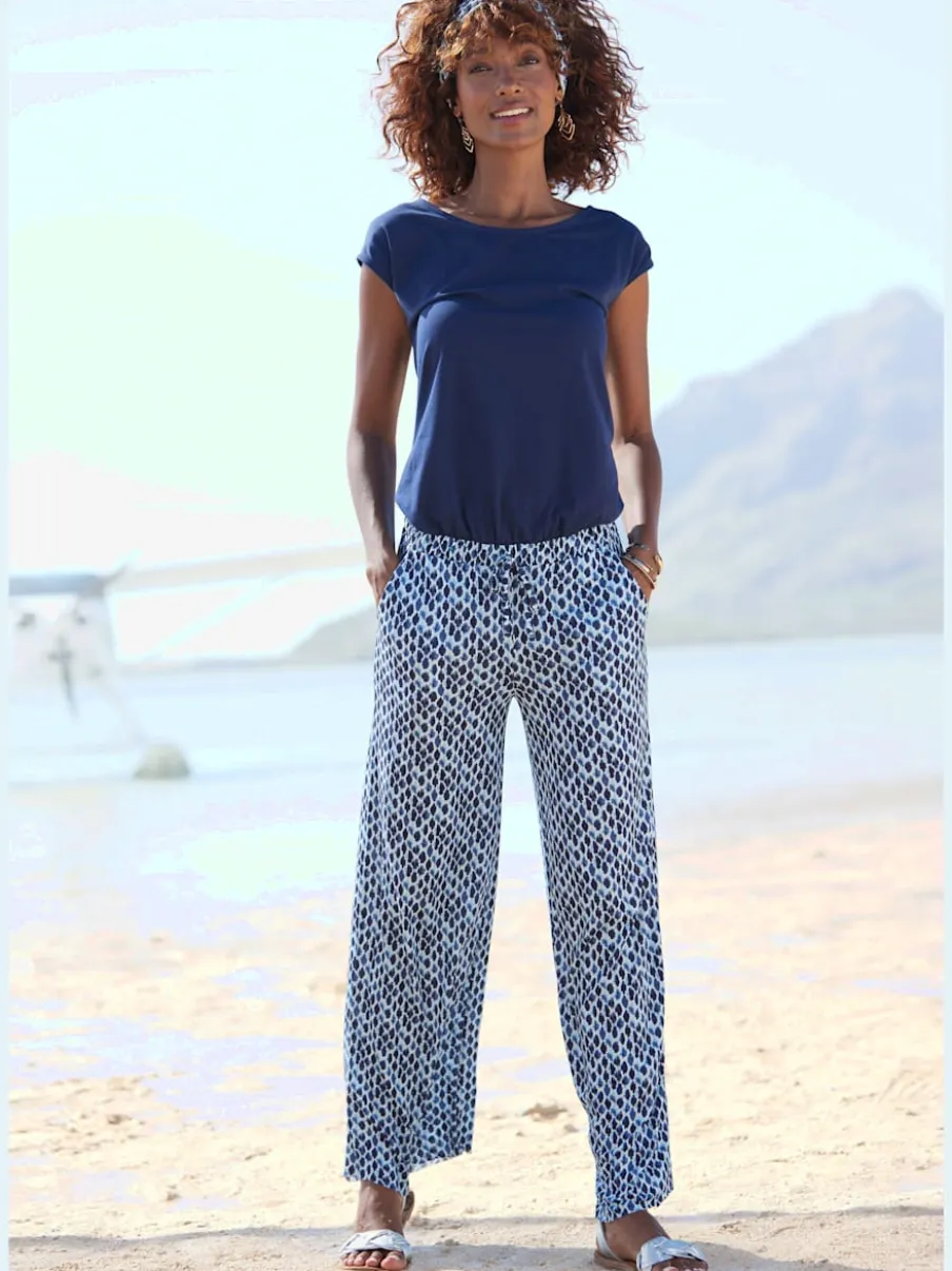 Combinaison avec col arrondi et manches courtes en viscose fluide à jambes extra-larges et poches fendues