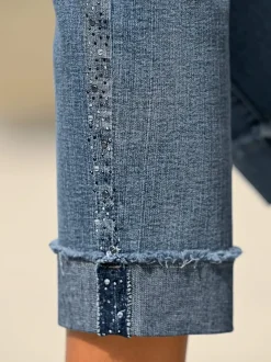 Jean denim doux avec bijoux fantaisie et revers.