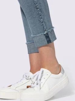 Jean denim doux avec bijoux fantaisie et revers.
