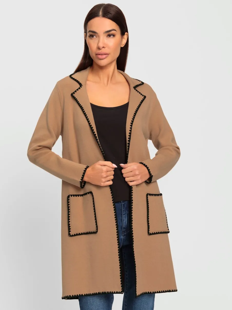 Manteau en tricot avec coutures contrastées et broderies