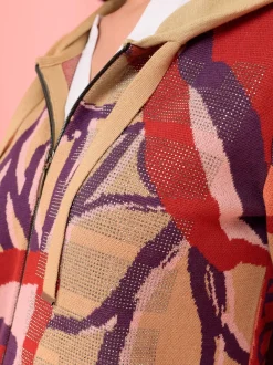 Veste à capuche en tricot avec inscription et pierres.
